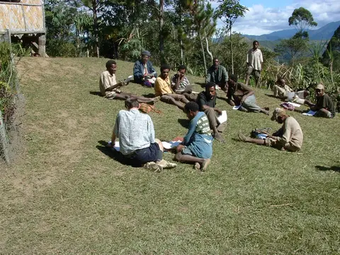 people on a hillside checking the Bible translation